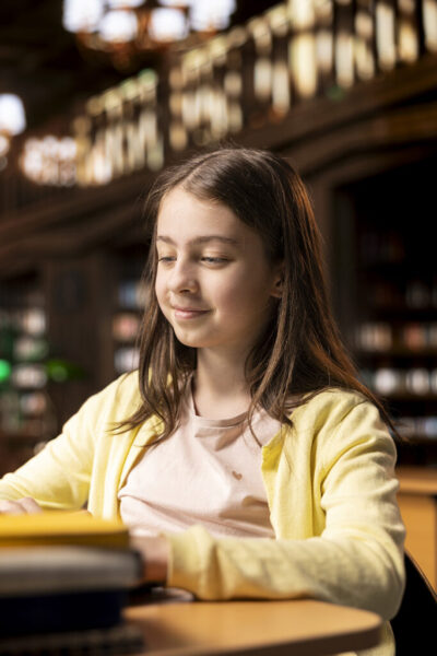 Young scholar takes notes for a descriptive essay work on laptop